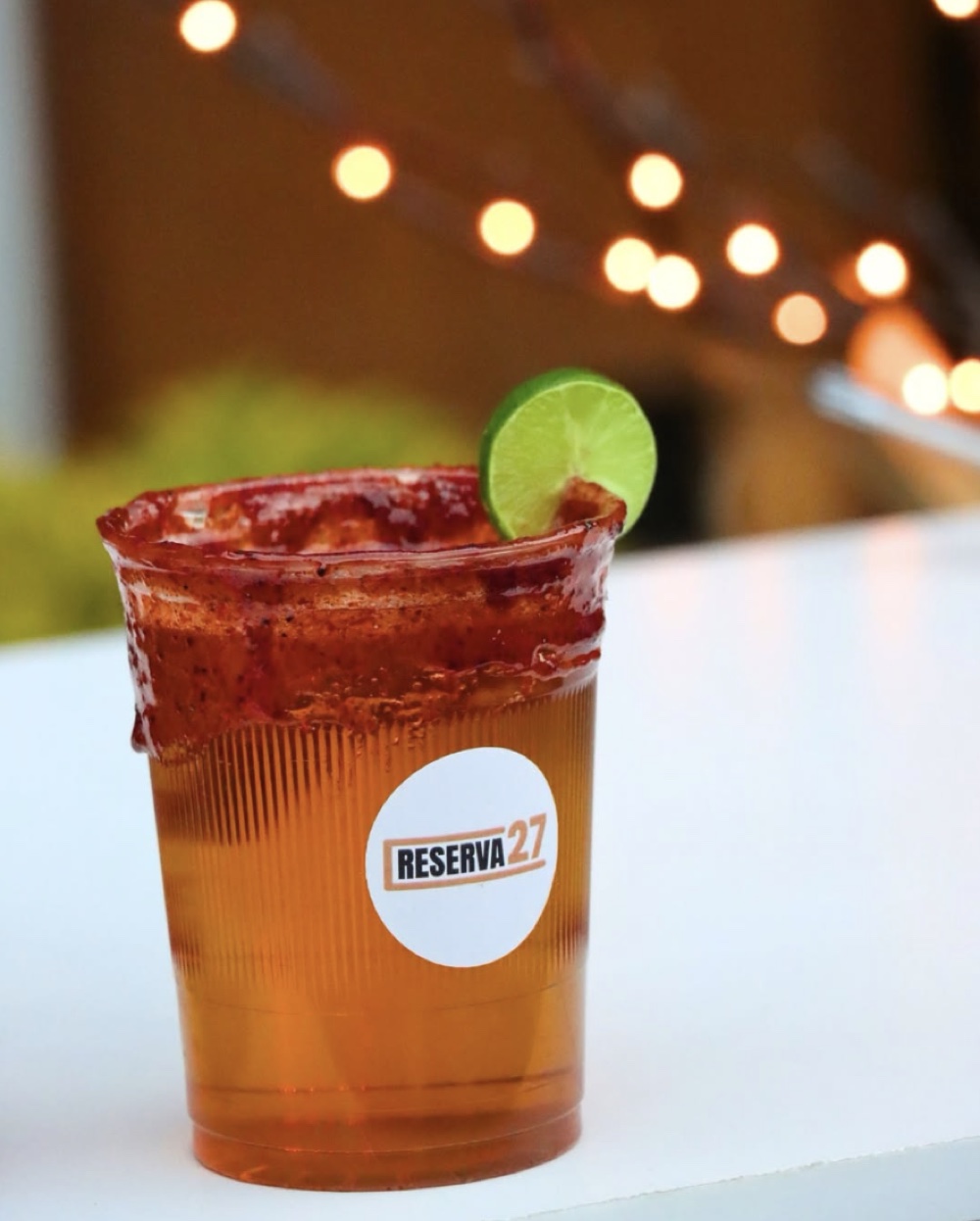 Michelada de Reserva 27 servida en un evento nocturno con luces.